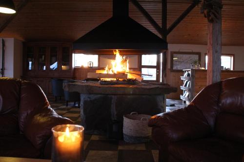 a fireplace in a living room with two leather couches at Hótel Á in Reykholt