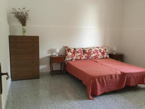 - une chambre avec un lit et une commode avec une couverture rouge dans l'établissement Villetta con giardino, à San Pietro in Bevagna