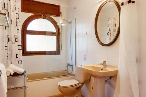 ein Badezimmer mit Waschbecken, Toilette und Spiegel in der Unterkunft Angela in Tamariu