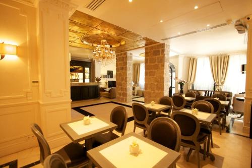 a restaurant with tables and chairs in a room at Hotel De Monaco in Cap d'Ail