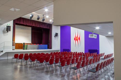 a room with red chairs and a purple wall at ETHIC ETAPES DIJON Accueil 24h24 et parking gratuit in Dijon