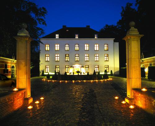a large white building with lights in front of it at Hotel Kasteel Solhof in Aartselaar