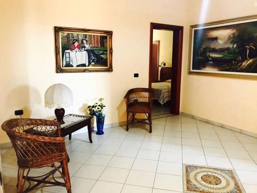 a living room with chairs and a table and a painting at Hotel Ristorante La Decanata in Le Castella