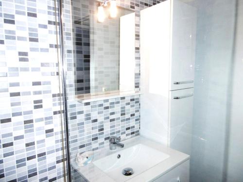 La salle de bains est pourvue d'un lavabo et d'une douche avec un miroir. dans l'établissement Maisonnette Katell, à Sarzeau