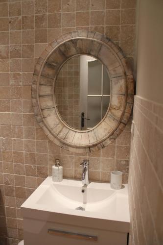 une salle de bain avec un lavabo et un miroir dans l'établissement Vintage Vert, à Lahitte-Toupière