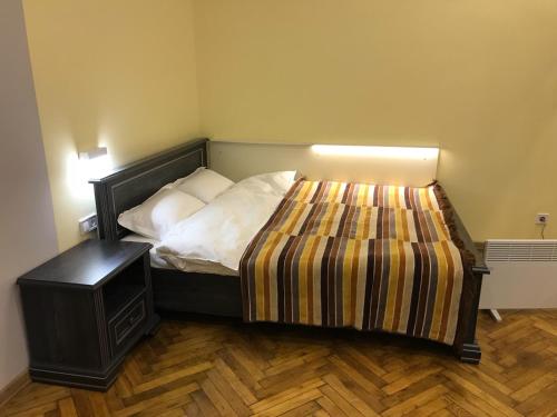 een kleine slaapkamer met een bed en een nachtkastje bij Apartment on Khorvatska Street in Lviv