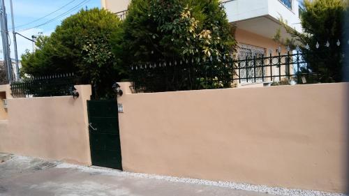 a fence in front of a house with trees at Markella's House in Vravrona