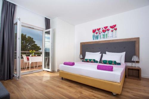 1 dormitorio con 1 cama grande y balcón en Pansion Mlikota en Promajna