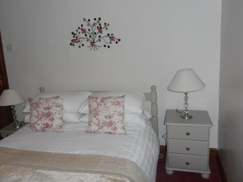 a bed with two pillows and a clock on the wall at Midtown Farm Bed & Breakfast in Easton