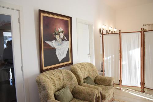 a living room with a chair and a painting on the wall at Casa da Paleta in Castelo de Vide