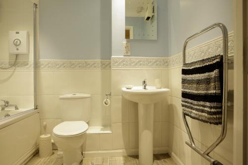 a white bathroom with a toilet and a sink at Newly refurbished 1 bed first floor apartment with wifi in Cosham