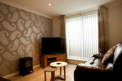 a living room with a couch and a flat screen tv at Newly refurbished 1 bed first floor apartment with wifi in Cosham