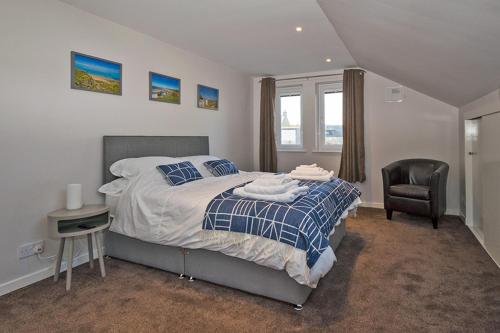 - une chambre avec un lit et une chaise dans l'établissement 37A Commerce Street, à Lossiemouth