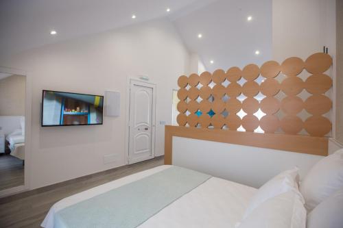 ポルトノボにあるLofts Complejo Playa Marのベッドと薄型テレビのある寝室