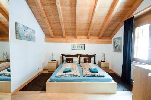 a bedroom with a bed with a wooden ceiling at Luxury Family Apartment in Lauterbrunnen