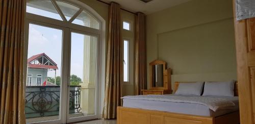 a bedroom with a bed and a large window at Hai Dang Hotel in Ho Chi Minh City