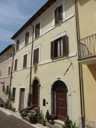 a large yellow building with a brown door at La Casa nel Borgo in Torre Orsina
