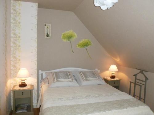 a bedroom with a bed with flowers on the wall at Jardin du Levant in Combourg