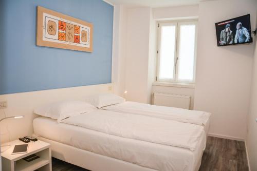 Un dormitorio con una cama blanca y una ventana. en Rivacentro, en Riva del Garda