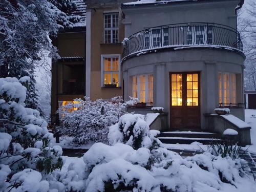 a house with a lighted door in the snow at Willa Marysin in Maków Podhalański