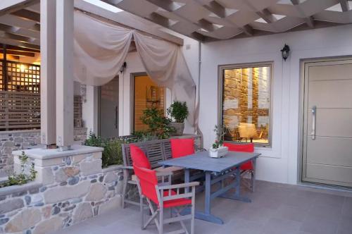 法勒薩納的住宿－On the water lodging 2，一个带蓝色桌子和红色椅子的庭院