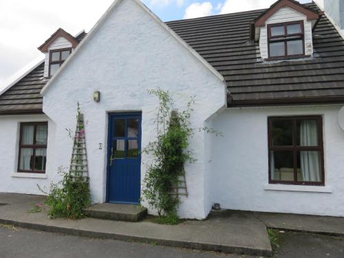 a white house with a blue door at BunkHouse - Letterfrack Farm in Letterfrack