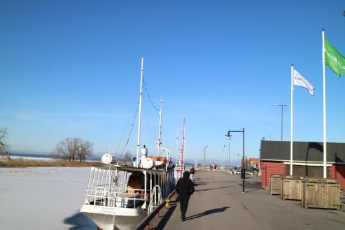 a man standing next to a boat in a dock at Vänerport Lakefront Hotell in Mariestad