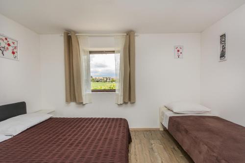 a bedroom with two beds and a window at Apartments Mijat in Novigrad Istria