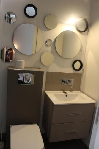 une salle de bain avec un lavabo et des miroirs au mur dans l'établissement Villa Le Ruisseau, à Cannes