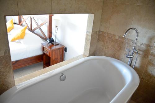 a bath tub in a bathroom with a bedroom at La Pasion Colonial Hotel Boutique By Bunik in Playa del Carmen