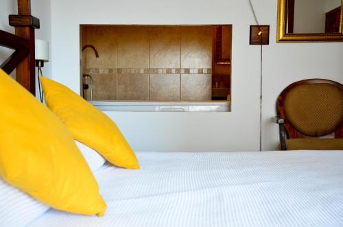 a bedroom with a bed with yellow pillows at La Pasion Colonial Hotel Boutique By Bunik in Playa del Carmen