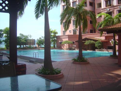 una piscina en medio de un edificio con palmeras en Marina Condominium Holiday Homestay en Kota Kinabalu