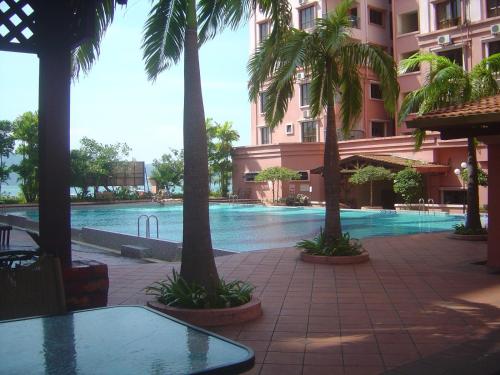 a swimming pool in the middle of a building with palm trees at Marina Condominium Holiday Homestay in Kota Kinabalu