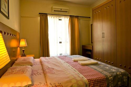 亞庇的住宿－濱海碼頭公寓酒店，一间卧室配有一张床,上面有两条毛巾