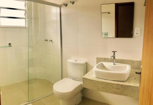 y baño con aseo, lavabo y ducha. en Hotel Pousada Santos, en Pinheira