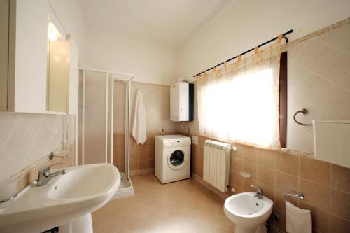 a bathroom with a sink and a washing machine at La Dimora dell'800 in Trapani