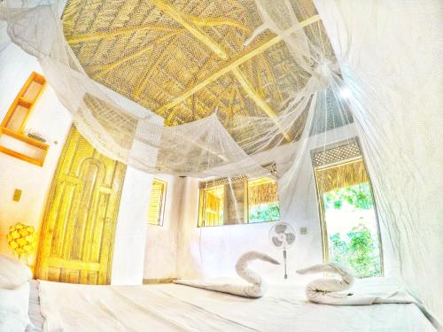 Un dormitorio con un techo con serpientes en una cama. en coin perdu guest house, en Jacmel