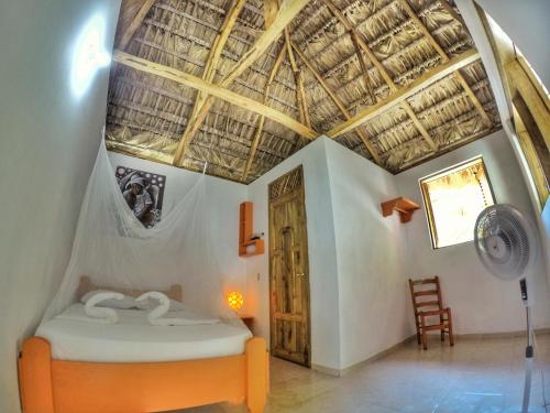Un dormitorio con una cama y un techo de madera. en coin perdu guest house, en Jacmel