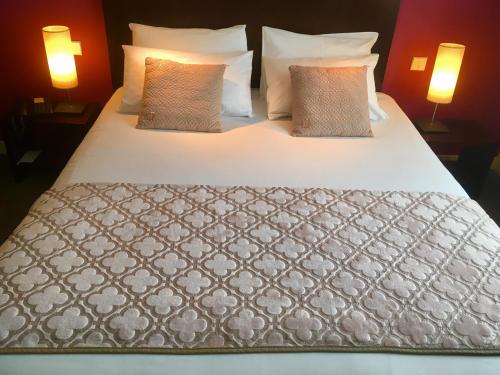 a large bed with white sheets and pillows at Best Western Adagio Saumur in Saumur