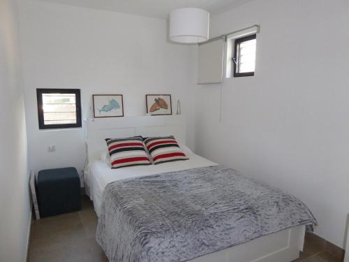 - une chambre blanche avec un lit et deux oreillers dans l'établissement Villa Lucienne Bandol, T2, 4 étoiles avec garage, calanques, à Bandol