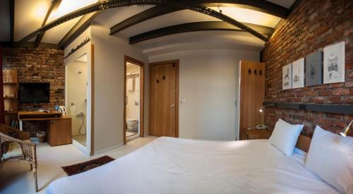 a bedroom with a large bed and a brick wall at Peradays in Istanbul
