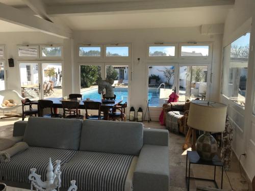 a living room with a couch and a table and a pool at Maison l'Etrier in Saintes-Maries-de-la-Mer