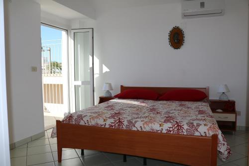 a bedroom with a bed and a sliding glass door at Le Case dei Pescatori - Coccinella Rossa in Ponza
