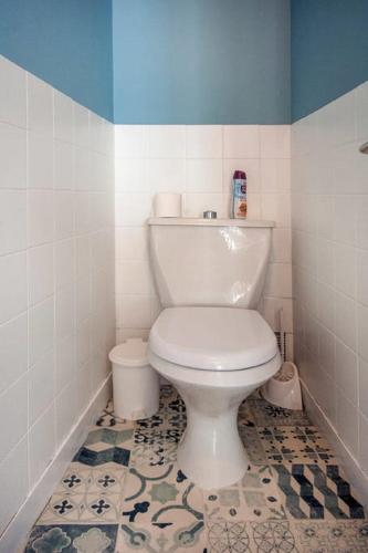 La salle de bains est pourvue de toilettes blanches et d'un mur bleu. dans l'établissement Appart PP, à Douarnenez
