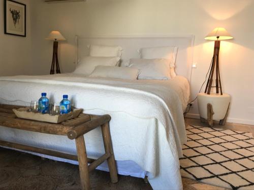 a bedroom with a large white bed with a wooden table at Maison l'Etrier in Saintes-Maries-de-la-Mer