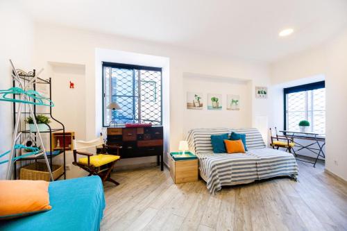 a living room with a couch and a bed at Madragoa - PLUS in Lisbon