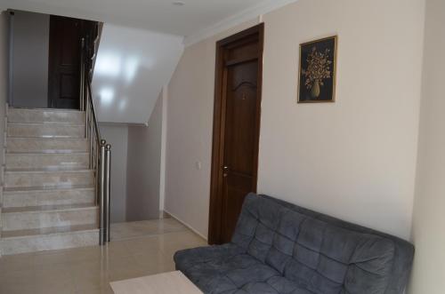 a living room with a couch and a staircase at Hotel Toni in Gudauri