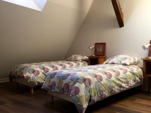 2 nebeneinander sitzende Betten in einem Schlafzimmer in der Unterkunft Les Gites Saint Aignan - Proche du Zoo de Beauval in Saint-Aignan