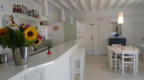 a white kitchen with a counter and a table and chairs at Matina Hotel in Mikonos