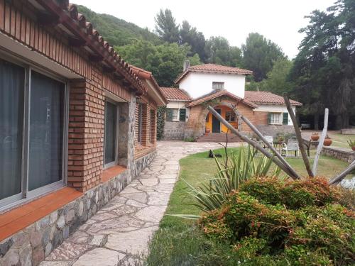 a house with a stone walkway next to a building at Hotel Zapata in La Cumbre